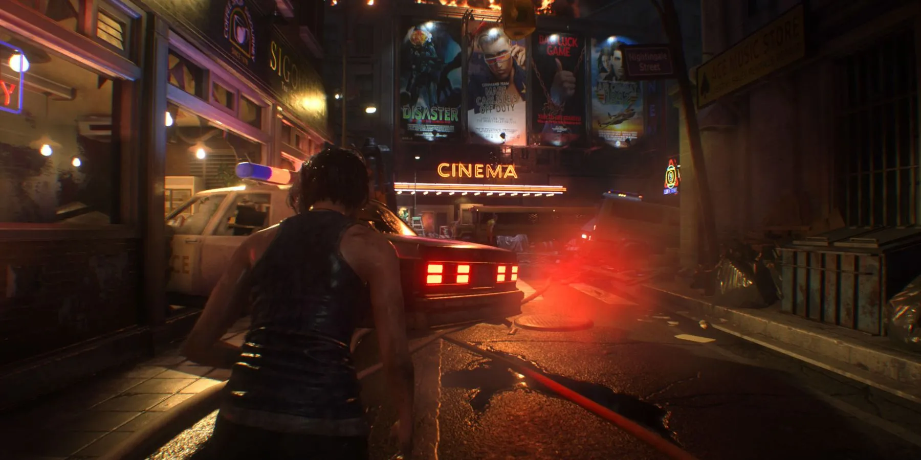Jill Valentine trên đường phố Racoon City với biển hiệu rạp chiếu phim và xe cảnh sát trong Resident Evil 3 Remake