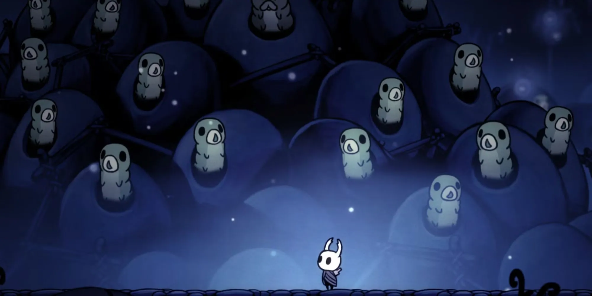Nhân vật hiệp sĩ nhỏ đứng trước các Grub bị nhốt trong game Hollow Knight