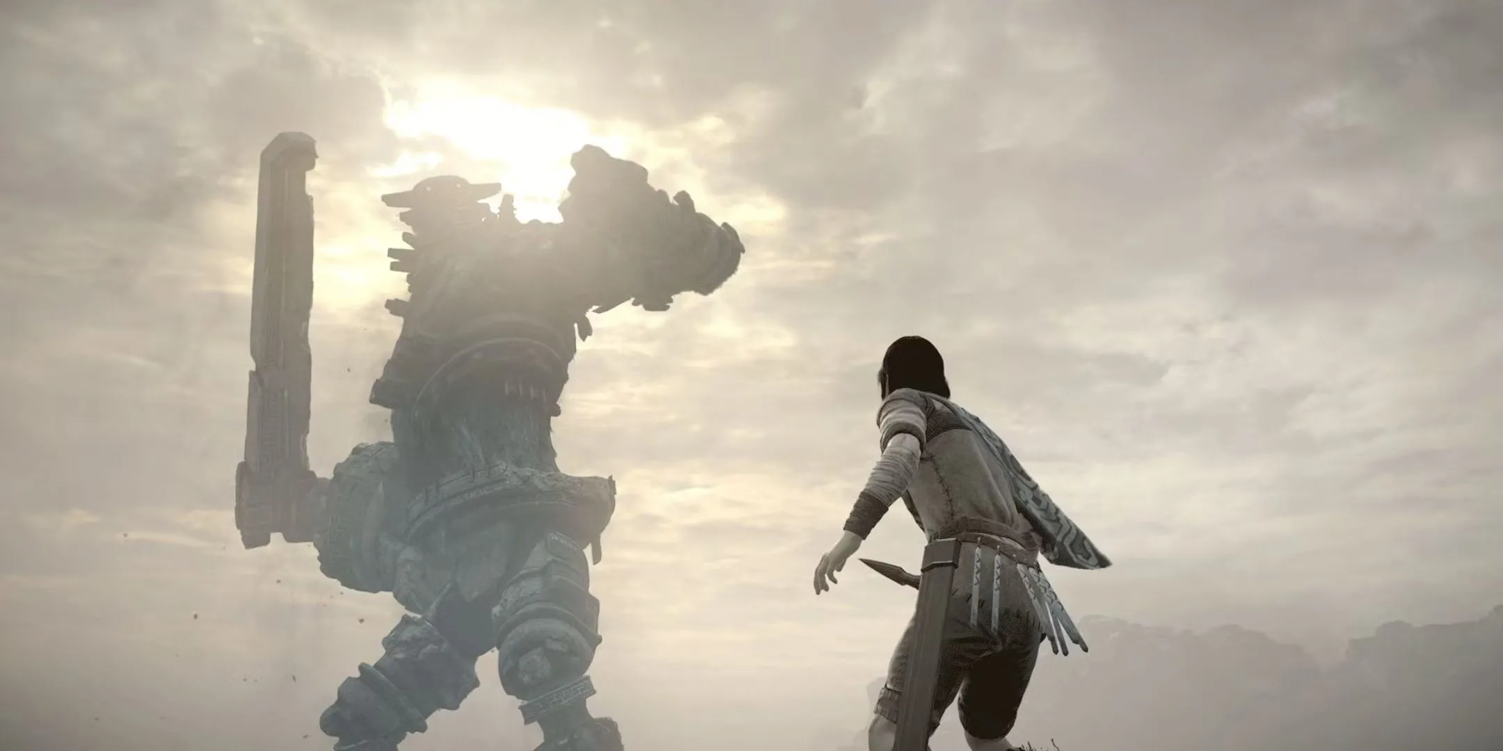 Nhân vật Wander giương kiếm nhìn lên một Colossus khổng lồ trong game Shadow of the Colossus